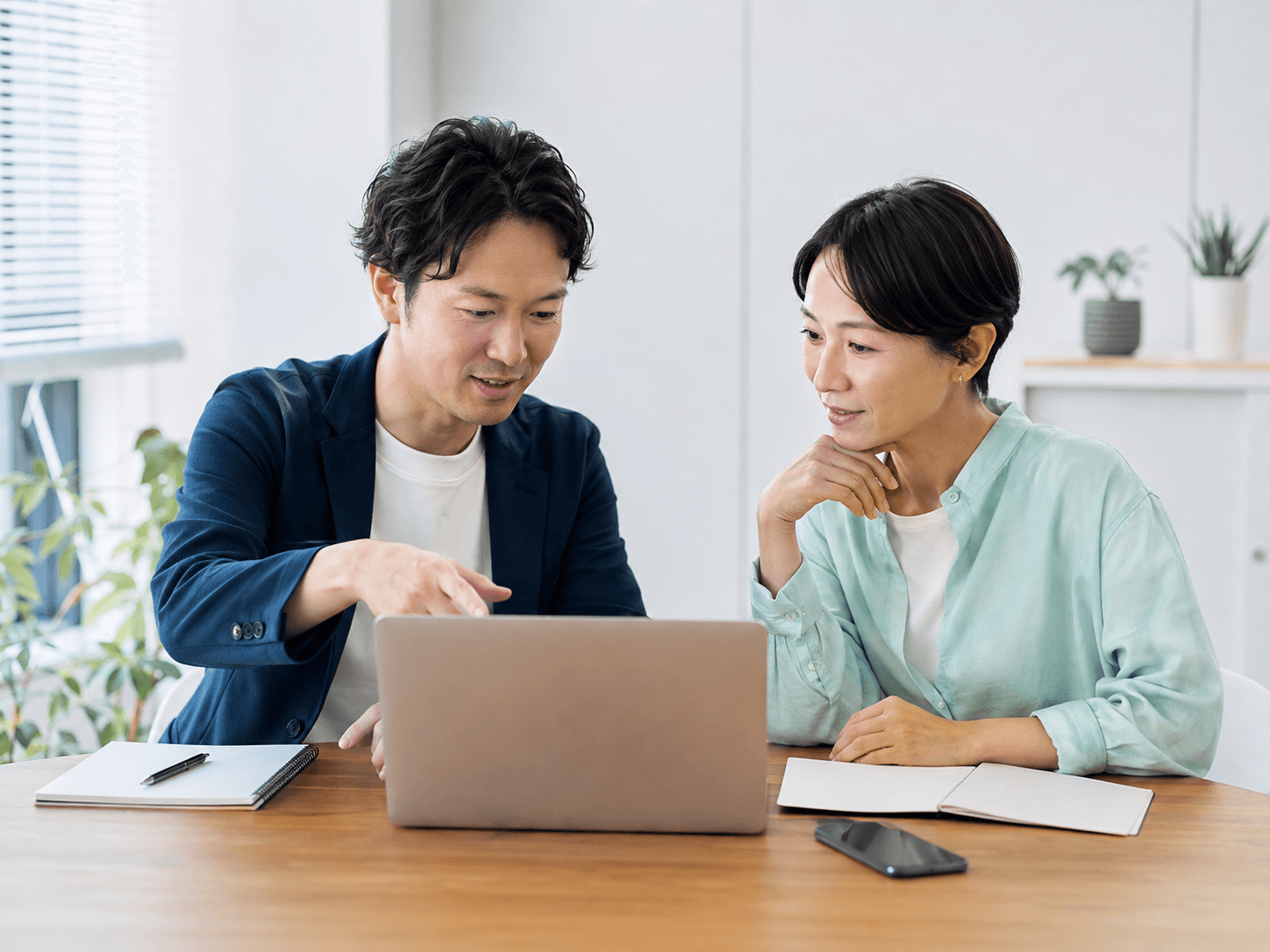 事業者と制作者がノートパソコンを見ながら予約ページの内容を相談している様子